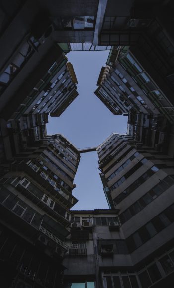 A low angle shot of tall apartment buildings under the dark sky